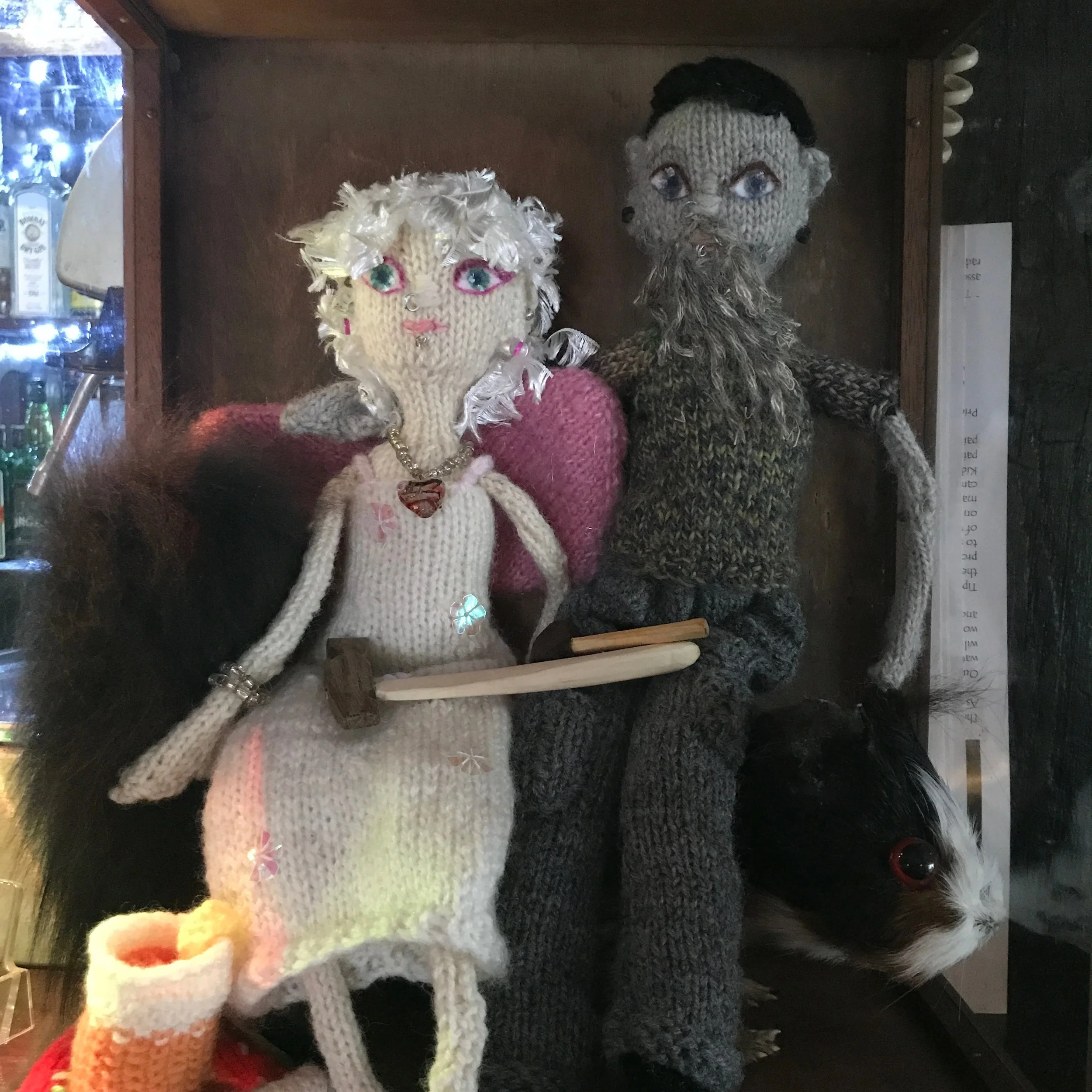 The pub landlord and landlady, knitted. That's a knitted cocktail and a knitted slice of lemon at her feet. sitting on a knitted slice of pizza. it's delightful.
