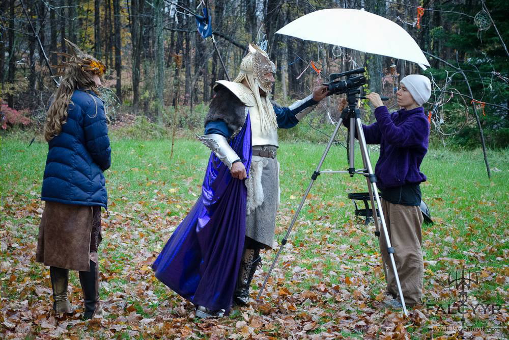 Keeping warm while they set up the camera for our scene. You can't see the rain but that is why they needed the umbrella. Photo credit: Unicovia Pictures