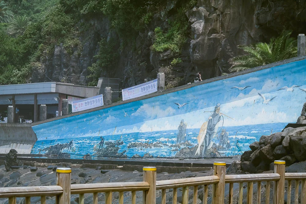 intricate murals along the water's edge at Jungmun Beach