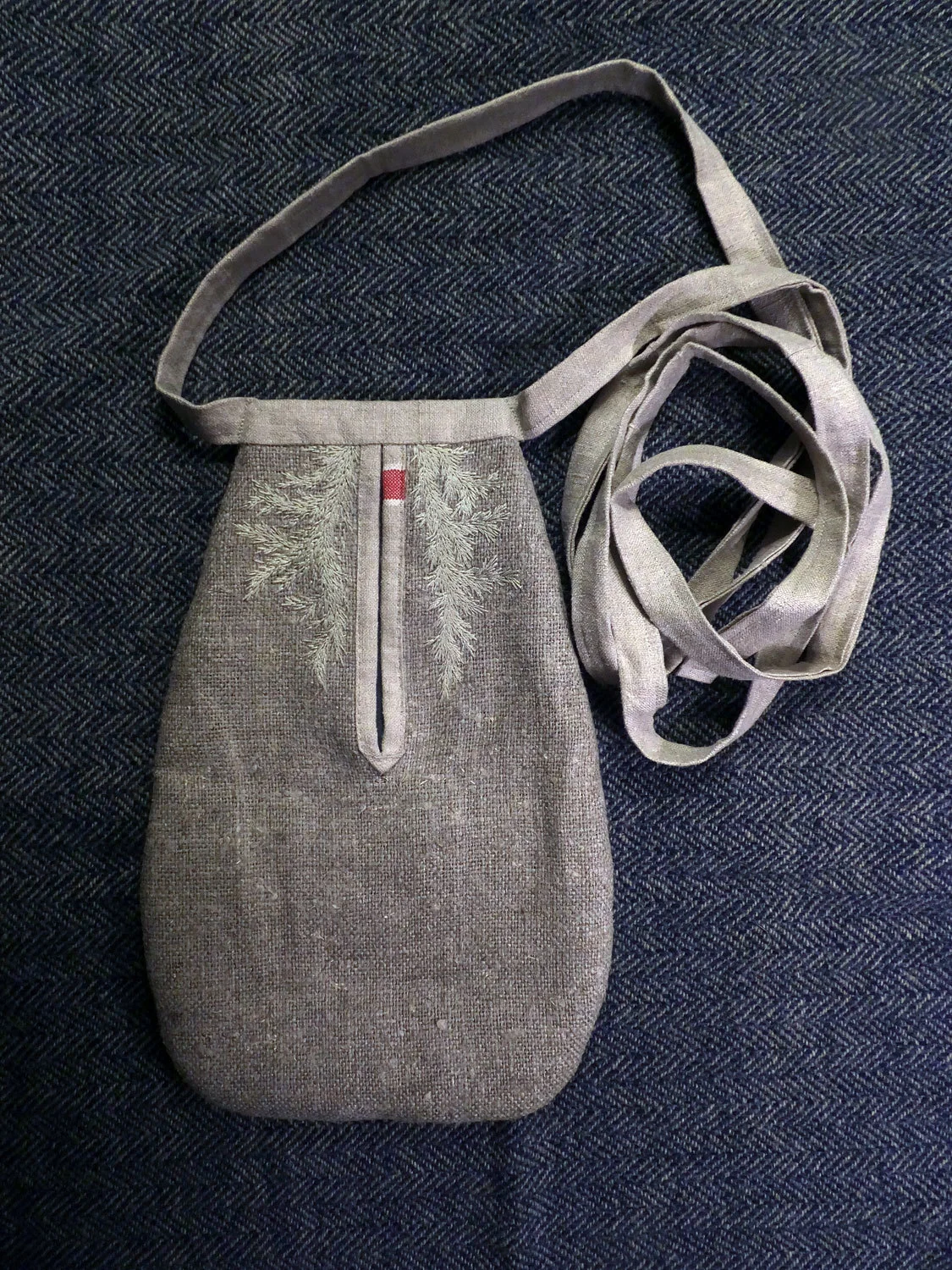 Scotch Draper Gathering Pocket by Artist Erin Endicott shown on top of a grey/blue Scottish wool tweed woven by Christine Mauersberger. photo: C. Mauersberger