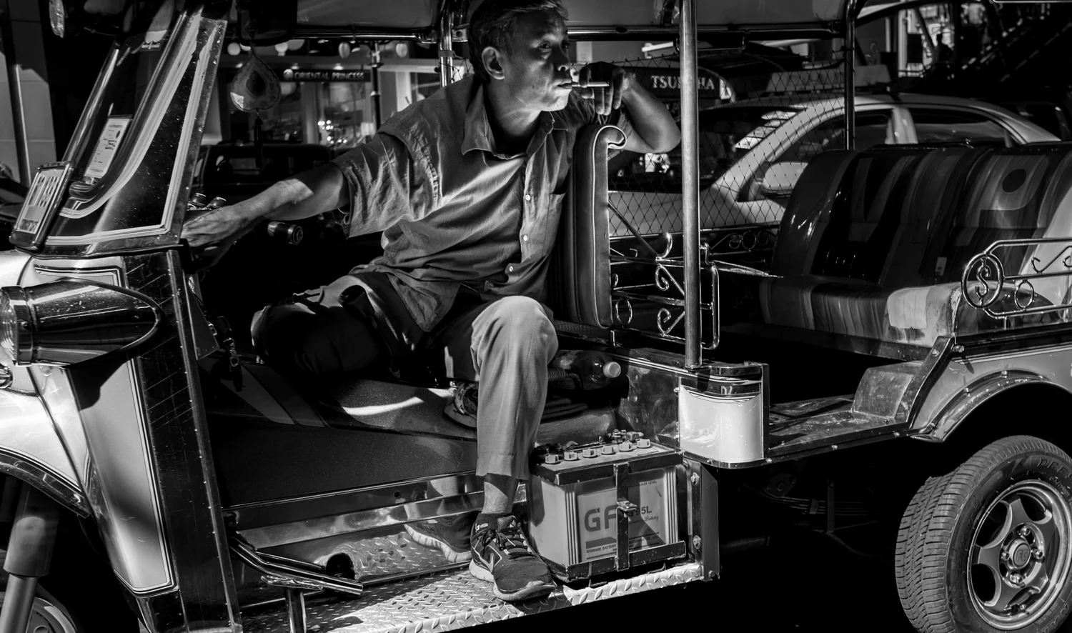 A tuk tuk driver waits for a fare.