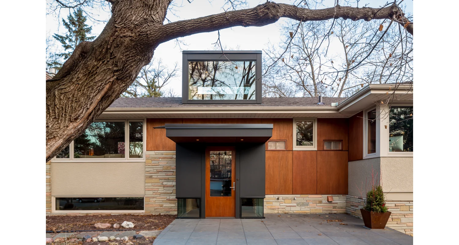 NEW LIFE AT THE SPLIT-LEVEL Built in the mid 60’s, this wonderful split level home had been updated over the years. Unusual to this era of home, the kitchen, living, and dining are in an area 40’ long by 16’ wide, creating an experience of being close to the outdoors. The one space that was never updated was the entry. Small and cramped, it was the only place in the house that was on “ground level”, yet also the most disconnected from the outside. Three elements were identified and distilled to respond to this condition, connecting the house to the ground through the entry experience. The floor plane: Here we built a new raised front patio and paved the surface, including the entry landing, and the treads and risers, with a course bluestone ceramic paver. The continuation of this surface, flowing inside and out, highlights the “split” in the home as the place of connection to the outside. The wrapper: We struck two lines marking this in-between zone of the landing; a strong existing window line of the basement level, and the new ceiling plane of the entry aligned with the top of the new interior railing. Below this zone is glass, drawing your attention to the ground, allowing the floor to visually move inside and out. Above, a wood surface wraps the interior and defines the entry. The pattern, laser etched into the wood, references the ashlar of the existing stone and transforms from wall to screen as it moves around the space. The sky: The old entry was short, dim, and confined. The new entry rises up and brings light over the full entry stairwell, filling the center of the house. The front monumental window is always dappled by the mature oak that anchors the site. Photographer: Brandon Stengel www.farmkidstudios.com Location: St. Louis Park, MN Completed: 2013 Project Team: Ben Awes AIA, Principal-In-Charge Bob Ganser AIA Christian Dean AIA Nate Dodge