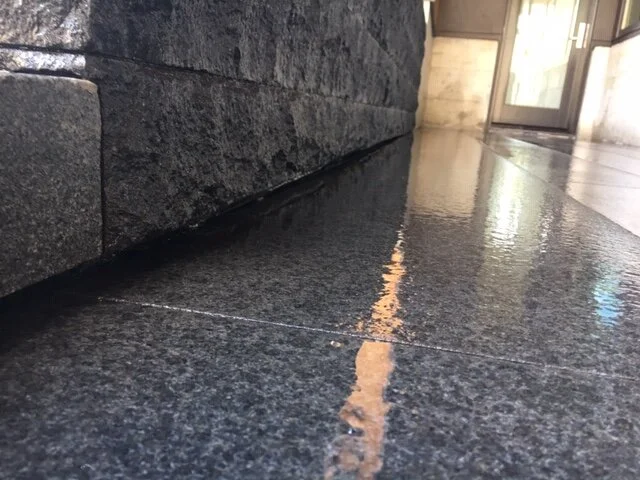  We undercut all the wall stone and the granite riser and installed a hidden drain channel so there was no disruption of the aesthetics and experience of the double entry way. 