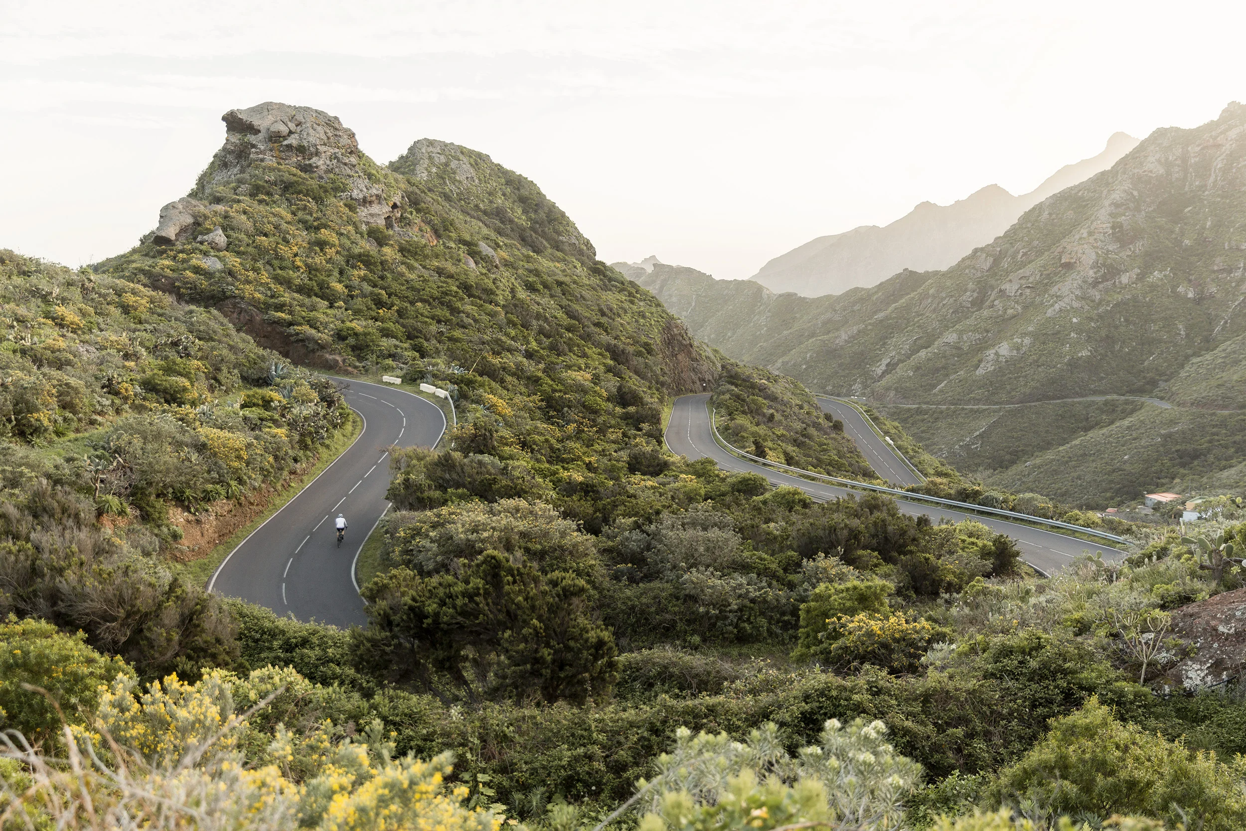 A man bikes up a winding road in Tenerife in the Canary Islands by Rebecca Stumpf, Denver Boulder Colorado Editorial and Commercial Photographer.