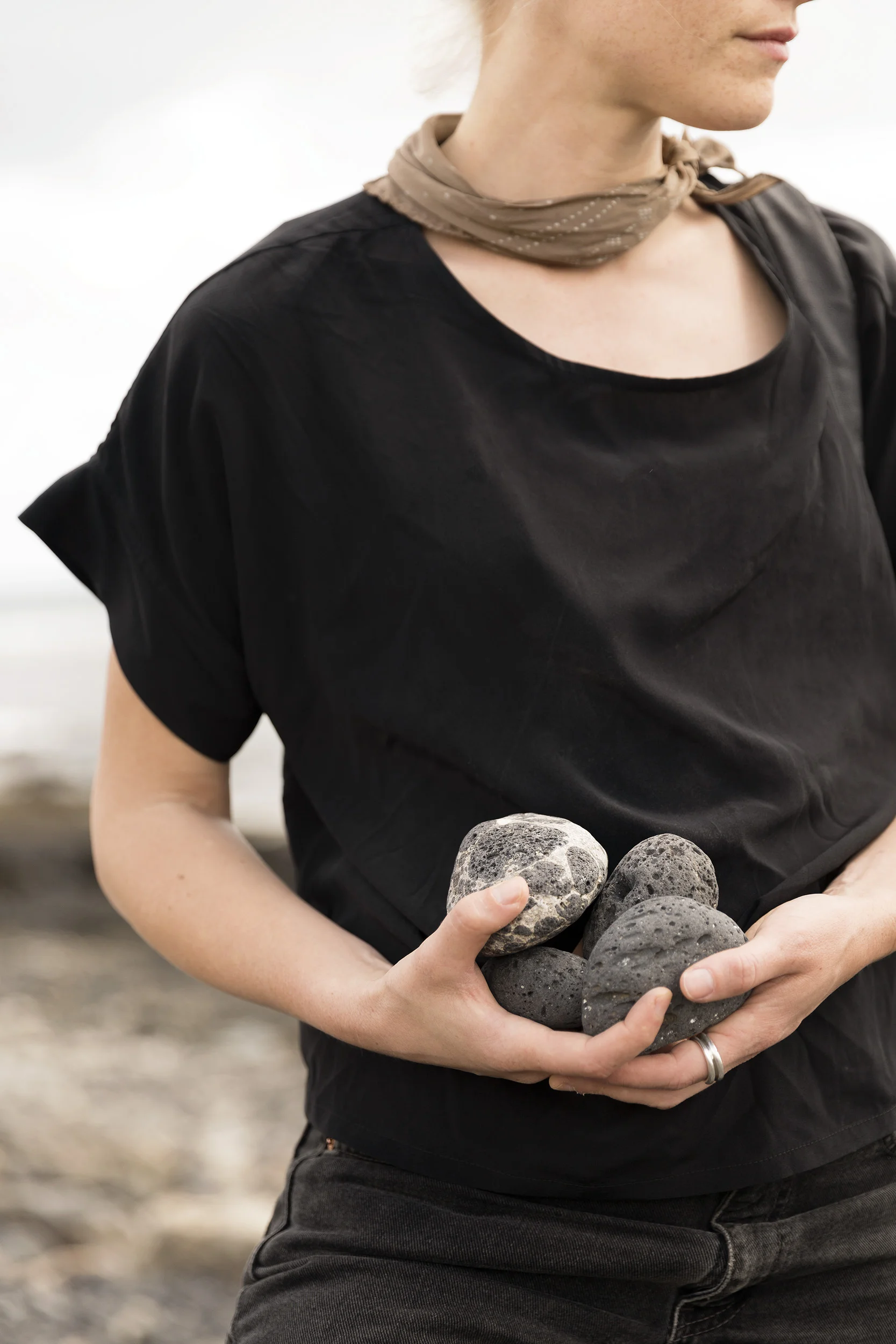 A woman collects volcanic rocks in the Canary Islands by Rebecca Stumpf, Denver Boulder Colorado Editorial and Commercial Photographer.
