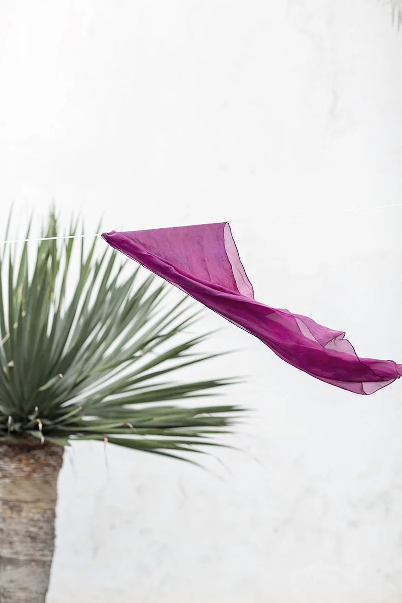A scarf dyed with cochineal blows in the wind by RebeccaStumpf.Food.Travel.Lifestyle.Denver.Boulder.Colorado.Photographer
