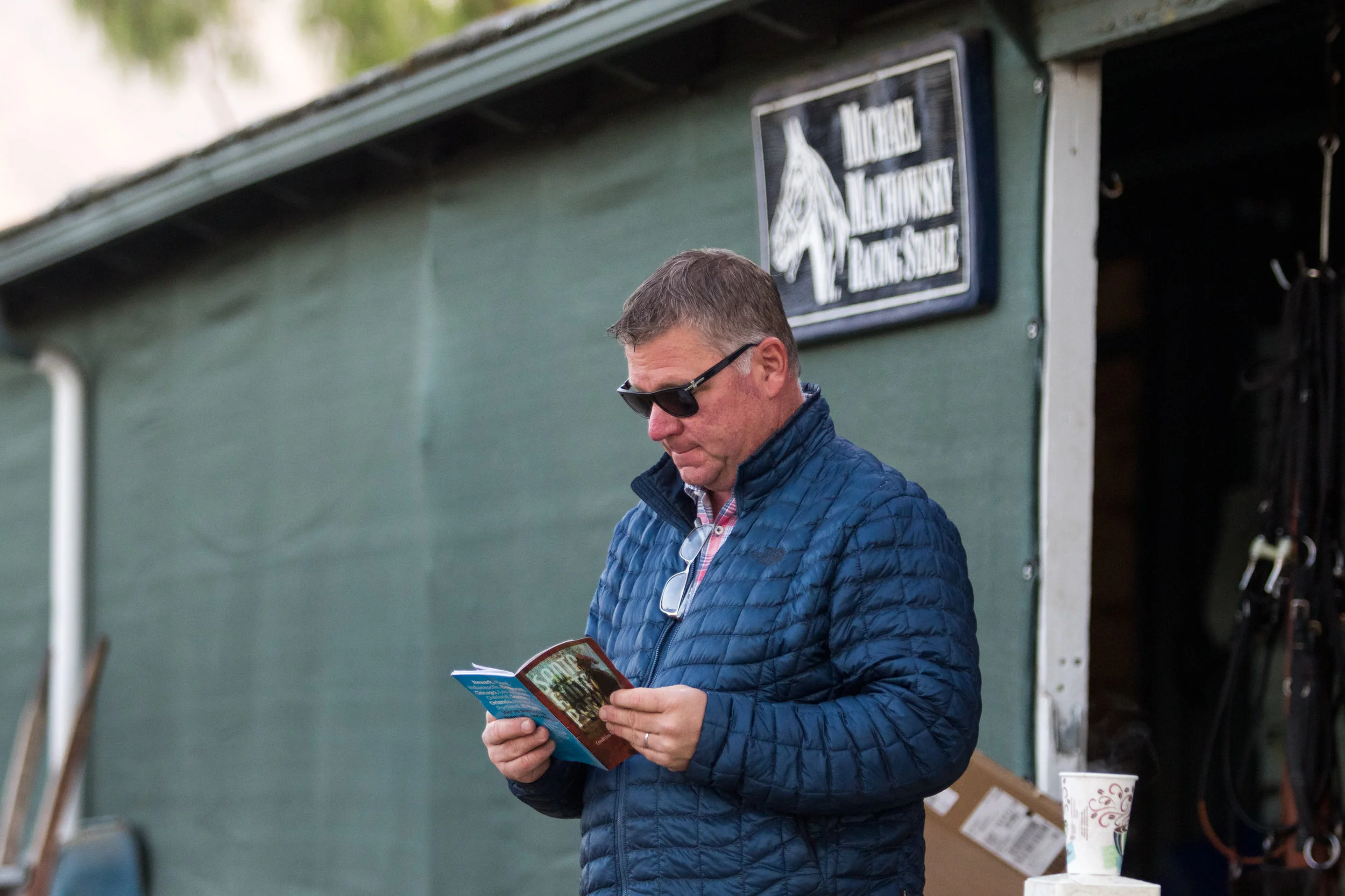 In Southern California, the San Gabriel Mountains serve as the backdrop to Santa Anita Park, the home of many top trainers, including Michael Machowsky Stables. Machowsky has been based on this circuit for 34 years, from the time he worked as assistant trainer and stable foreman for Richard Mandella for almost six years before he went out on his own. Recently, Hall of Famer Mandella recalled Machowsky’s early days: “Mike was a young man when he worked for me. I was a younger man, too! He was a very devoted, hard-working young person who had nothing on his mind but racing horses. I have watched him grow through the years, he’s still that way and always puts his horses first. I’m in the Hall of Fame because of people like Mike Machowsky and so many others. They have propelled me to where I am now,” Mandella said. “Machowsky has a very good feel for horses, which is innate. He proves it year after year. It’s not something you can acquire. You have it or you don’t, and Machowsky has it!” Although Mandella was speaking in serious tones, a sense of pride was evident in his words. Machowsky credits his mentor with teaching him patience, and Mandella deflected the compliment from himself by saying, “We all learn patience from the horses.” Patience is not all that Machowsky took away from his time with Mandella. “I learned everything from him,” he said. “Detail, leaving no stone unturned on the horses -- those traits stayed with me. Mandella taught me it’s the little things that matter.” --------------------------------- The Sunday after Breeders’ Cup at Del Mar, Machowsky trainee Make It a Triple won a claiming race. Machowsky’s smile was as wide as any of the people representing owner Richard Barton in the winner’s circle. Afterwards, Machowsky celebrated his victory at the restaurant 14 Hands. The 5’ 11” trainer was sitting at a table, wearing a long-sleeved dress shirt, jeans, and the same smile from the winner’s circle. He stated, ”I always expect to win. We put everything into these horses: conditioning, proper diets, daily care. It’s my position to decide what type of race they should enter for a win. If things do not go right, I blame myself, as I should because I am with these Thoroughbreds every day and know them inside out.” Machowsky took out his trainer’s license in 1989 and saddled his first winner, Bidadip, on New Year’s Day at Santa Anita in 1990. Almost two years later, on December 22, 1991, Native Boundary became his first stakes winner, while Dancing Rhythm, winner of the Grade 3 Senorita Stakes in 1998, was his first graded stakes winner. In 2009, he won the $900,000 Sunland Derby with Kelly Leak, over future Kentucky Derby winner Mine That Bird in fourth. Born September 19, 1965, in Cincinnati, Ohio, Machowsky was two when his family moved to Southern California. He became interested in horses through his physician father’s ownership of Quarter Horses and, later, Thoroughbred racehorses. When the popular, nearly white colt Vigors -- winner of the 1978 Santa Anita Handicap -- caught Machowsky’s attention, he never looked back. He knew he had found his calling and would be relentless in its pursuit. He began working as a hotwalker and mucked stalls for trainer Clay Brinson after school and on weekends. At 15, he traveled to Del Mar with Brinson and stayed in a motorhome across the street from the track. He worked as a groom for trainer Henry Moreno for two years before moving to Mandella’s barn. Machowsky lives in Monrovia, California -- about a 10-minute drive from Santa Anita -- with Dana, his wife of 17 years; two daughters; and two stepdaughters. Besides being a real estate agent, Dana handles the business end of the stable and has always been a source of strength for her husband. As the daughter of a veterinarian, she has a unique understanding of the career she married into and is well aware of the ups and downs of the sport, and she takes each with grace. Bedtime for Machowsky is 8 P.M. He rises at 3:45 and makes his way to the coffeemaker for his first cup of java, arriving at Barn 17, less than an hour later, ready for work. “It’s a team effort here.” He elaborated, “It does not matter if it’s a stakes horse or a claiming horse, every horse gets the same unique individual care for whatever issues they are facing.” Most of his employees, who total nine grooms and two exercise riders, have been with him for many years. Heather Alvarado is Machowsky’s assistant and gets on horses -- usually her favorite ones -- for works. Hector Rangel is the barn foreman and helps the operation run smoothly. Maria Falgione still rides Machowsky’s horses in the mornings but last August at Del Mar fulfilled an ambition to ride races. In her very first start, Machowsky legged her up for a win on Barton’s Tee Em Eye last August at Del Mar. Falgione has gone to the post eight more times, with a second and a third. This is part of the reason Machowsky maintains such loyalty from his employees. Although the horses come first, he wants his employees to follow their dreams and will do everything in his power to make it happen. That kind of devotion commands loyalty. Over the years, there have been an array of unconventional treatments to settle a horse or just to make the horse happier. One filly was frightened and edgy, so Machowsky purchased a goat, who has an affinity for sour apple-flavored Jolly Rancher candy. Machowsky said, “Maggie, the goat, follows our hotwalker around like a dog because he pets her often.” Caracortado, a gelding Machowsky bred in California, had a taste for a different kind of candy, Skittles, as well as beer. Once the cheeky gelding’s many fans became aware of his love for Skittles, the stable began receiving the candy from all over the U.S. “Cara,” as Caracortado was affectionately known, got his name from a scar on his head. Machowsky had originally sent in the name “Scarface” to The Jockey Club, but it was declined because of the movie with the same name. Machowsky discovered that the Spanish word for scarface is “caracortado,” and that name was accepted. The chestnut gelding by Cat Dreams out of Mon’s Venus is a half- brother to 2017 Smarty Jones Stakes winner and Breeders’ Cup Classic participant Pavel. Caracortado was on the Kentucky Derby trail and raced for five years, winning the Grade 2 Robert B. Lewis Stakes in 2010, the Grade 2 Del Mar Handicap in 2011, and the Grade 3 Daytona Stakes in 2012. It was this last win, in the Daytona contested on Santa Anita’s downhill turf course on January 8, 2012, that was arguably his most thrilling. The dazzling gelding came from out of the clouds after announcer Trevor Denman had counted him out, calling, “Caracortado did not fire today!” But Caracortado did, indeed, fire; it was estimated that the gelding ran his final sixteenth of a mile in five seconds or less. After the Daytona, Caracortado was away from the races for a year and a half, coming back with a fourth-place finish in the Grade 3 Eddie D. Stakes before another setback saw him spend another 10 months on the sidelines. He made two more starts before retiring with a record of nine wins, two seconds, and four thirds in 22 starts, with earnings over $885,000. Machowsky lamented of Caracortado, “He was such an unbelievable horse…he could run on any surface, short, long, and downhill, and I’d planned on running him until he was 10 or 11 years old, but he developed foot problems. He even lost a frog on one of his front feet. We had an amazing farrier, and that is one of the main reasons he kept coming back to race. I had hoped to run the gelding for many more years but did not want to risk injury because of his foot issues.” He began looking around for a proper home for his beloved horse who his Lo Hi Stable owned with Blahut Stables LLC, Donkey Island LLC, and Kagele Brothers Inc. He did not have to look far. One of his former exercise riders, Jacqueline Kandalaft, had begun rehabbing OTTBs. She and her girlfriend took over the next stage in Cara’s career. He excelled at jumping, then they decided to try a new discipline, dressage, and Cara has found his niche. Machowsky occasionally drops by to see the progress his former stable star is making in his second career. Michael Machowsky does not do this just for his stable stars, but for any of his horses at the end of their racing careers. He does his best to find a rehab facility for each of them, knowing that for our sport to thrive, we must take care of our athletes before, during, and after they leave the track. Before Caracortado, there was another horse, Southern Image, who put Machowsky on the national scene. Southern Image won six-of-eight starts and, in the 2003 Malibu Stakes, provided the trainer with his first Grade 1 win. Southern Image gave Machowsky more Grade 1 success in the 2004 Santa Anita Handicap and Pimlico Special, earning more than $1.8 million along the way. Having grown up nearby, winning the Santa Anita Handicap was quite special for Machowsky. It was a case of the local boy making good. Ironically, the two favorites going into The Big ‘Cap were Southern Image and Mandella trainee Pleasantly Perfect. The match pitted Mandella’s former assistant against his mentor. Unfortunately, Pleasantly Perfect spiked a temperature and was scratched, but Mandella still saddled a runner in Olmodavor. That day, Machowsky’s horse won -- but perhaps the result may have been different if their paths had never crossed.