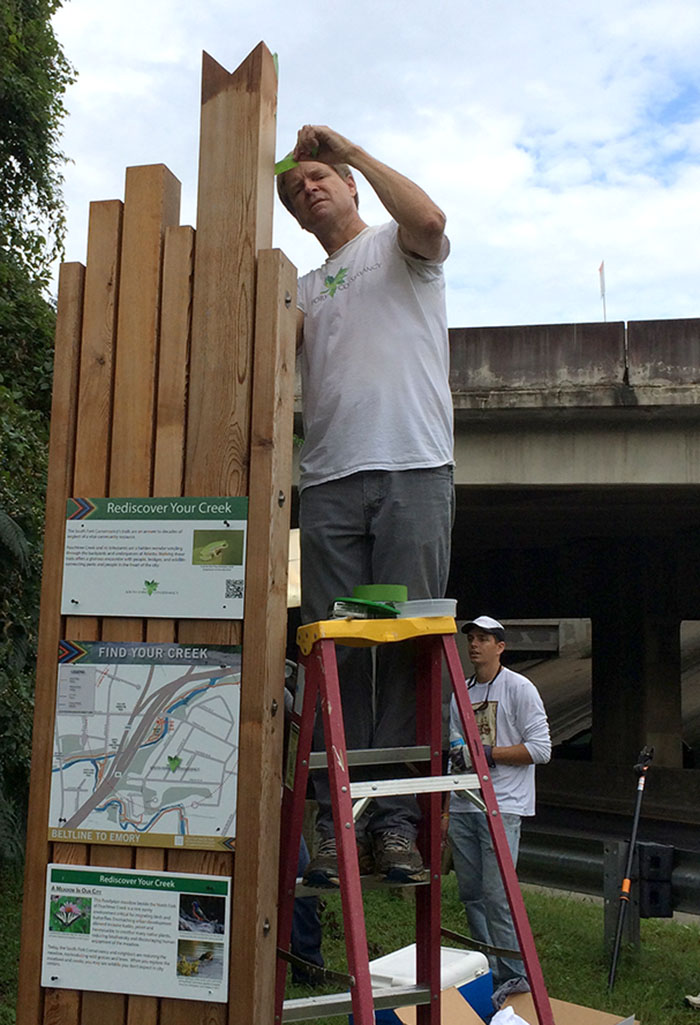 SFC board member Warner McConaughey installs signs at Lindbergh and Meadow Trail.