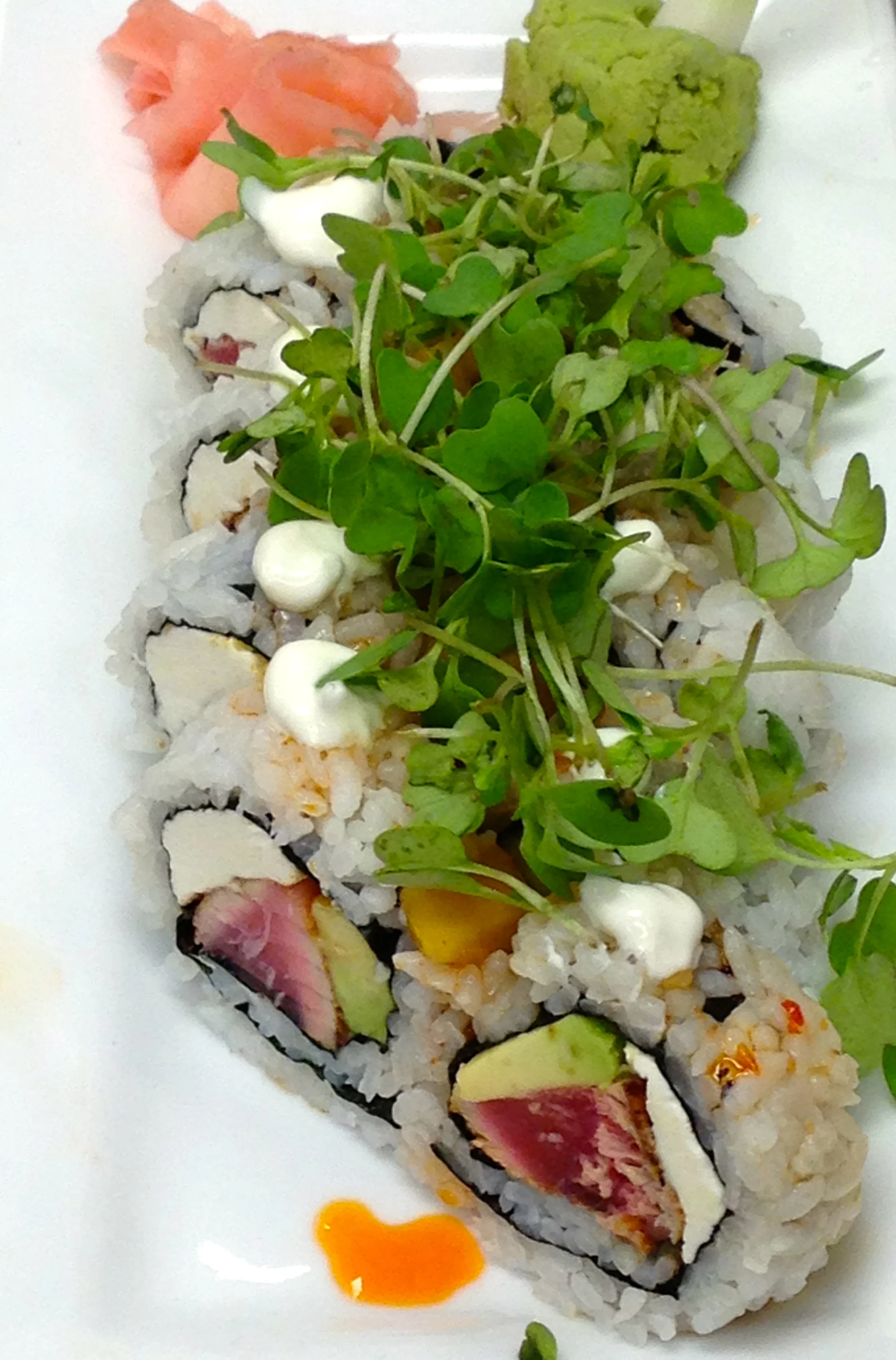 Blackened Tuna Roll with hot sesame oil, lime creme fraiche, mango salsa, and wasabi greens