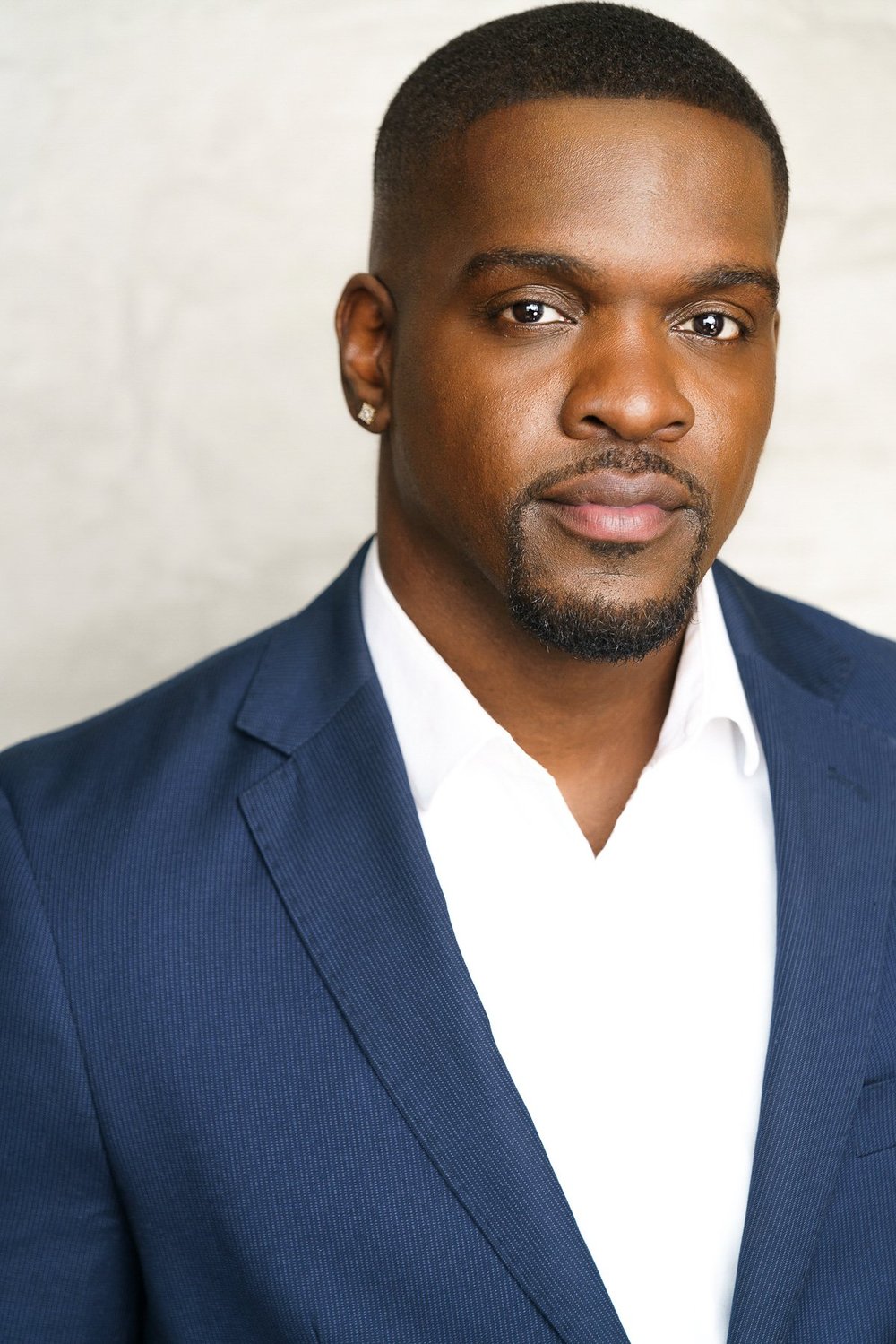 Headshot with a quiet expression and direct eye contact, photographed by Bradford Rogne