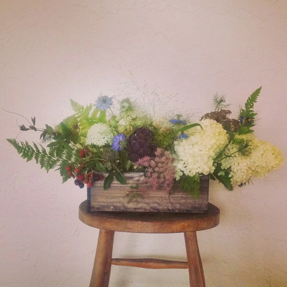 Centerpieces were design in reclaimed wood boxes and filled with seasonal flowers and berries and ferns from the woods.