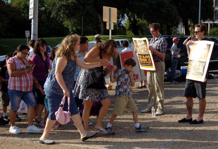 A family avoids protester's signs at the Barnum Circus during its stop in Austin, Texas