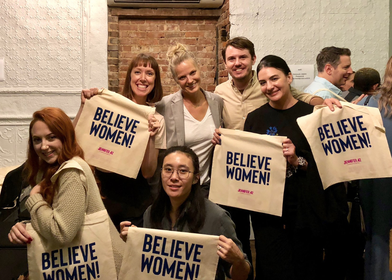 Intern Melissa Parsons, Hyde, Intern Hannah Ponder, Kamihira, Impact Producer Chris Gauthier, and Ruditskaya hold up the kickstarter reward for pledges.