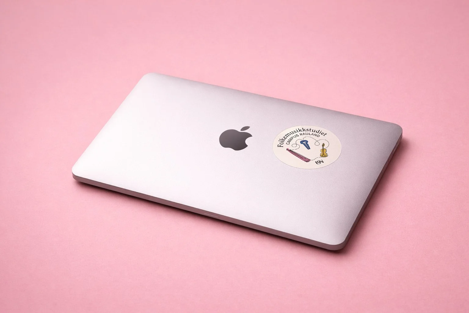 A mackbook laptop with a round sticker on it