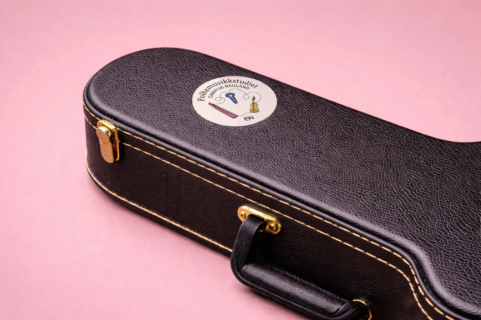 A black guitarcase with a round sticker on it