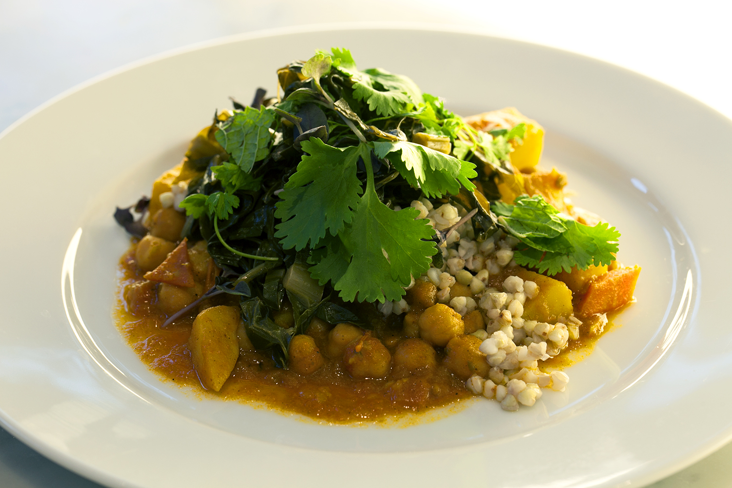 Chickpea and spiced summer veggie stew with buckwheat and slow cooked greens