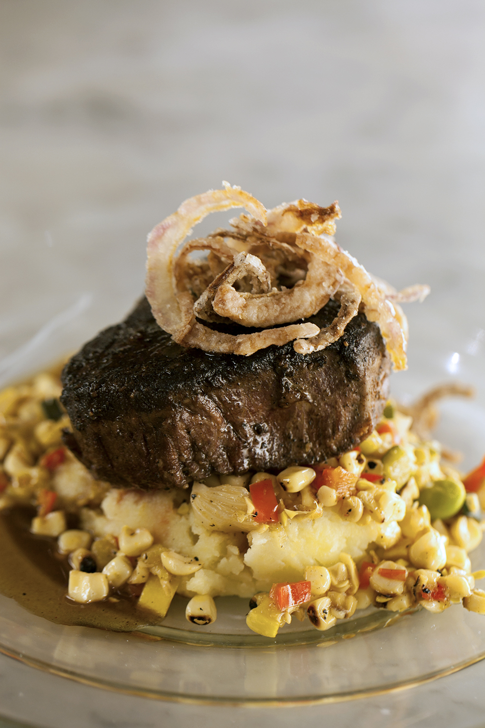 Blackened filet mignon with truffle mashed potatoes, charred corn and pepper succotash with bordelaise sauce