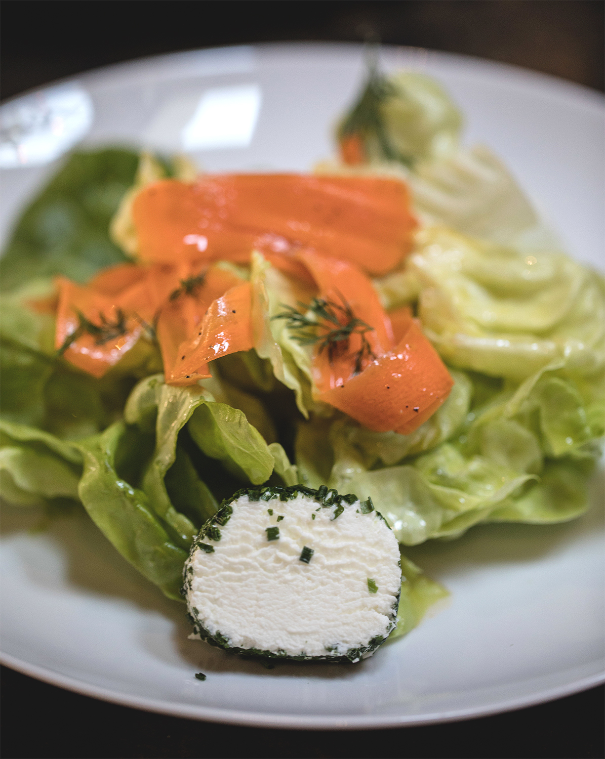 Bibb lettuce salad with carrot, red onion, herb cheese, and dill