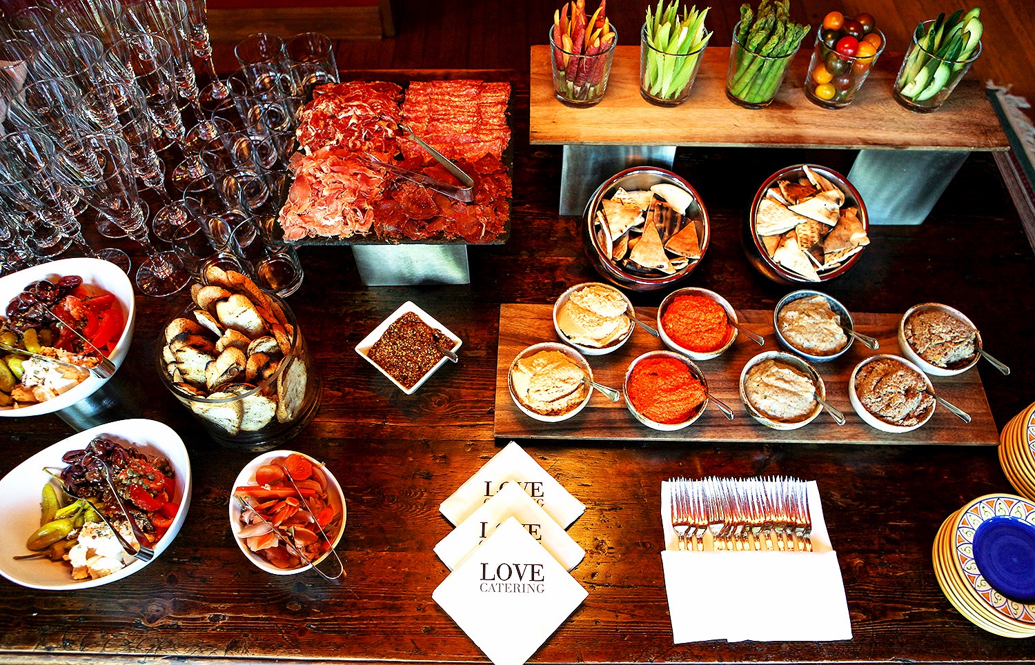 Appetizer station with antipasta, charcuterie, and crudite with assorted hummus