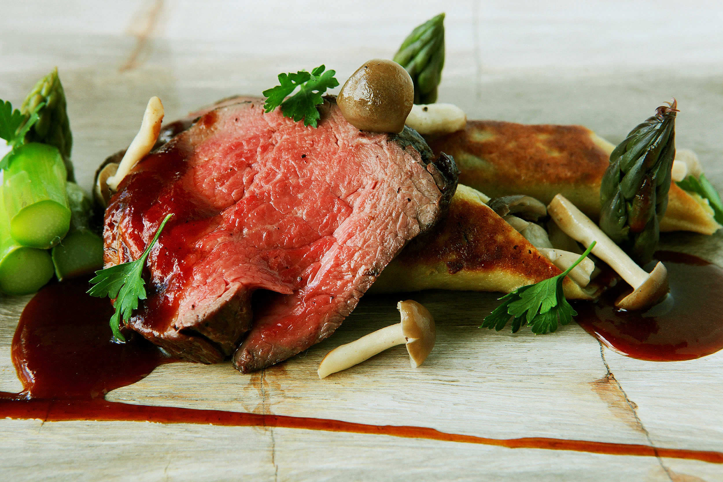 Beef tenderloin with red wine reduction, asparagus and chanterelle mushroom crepes