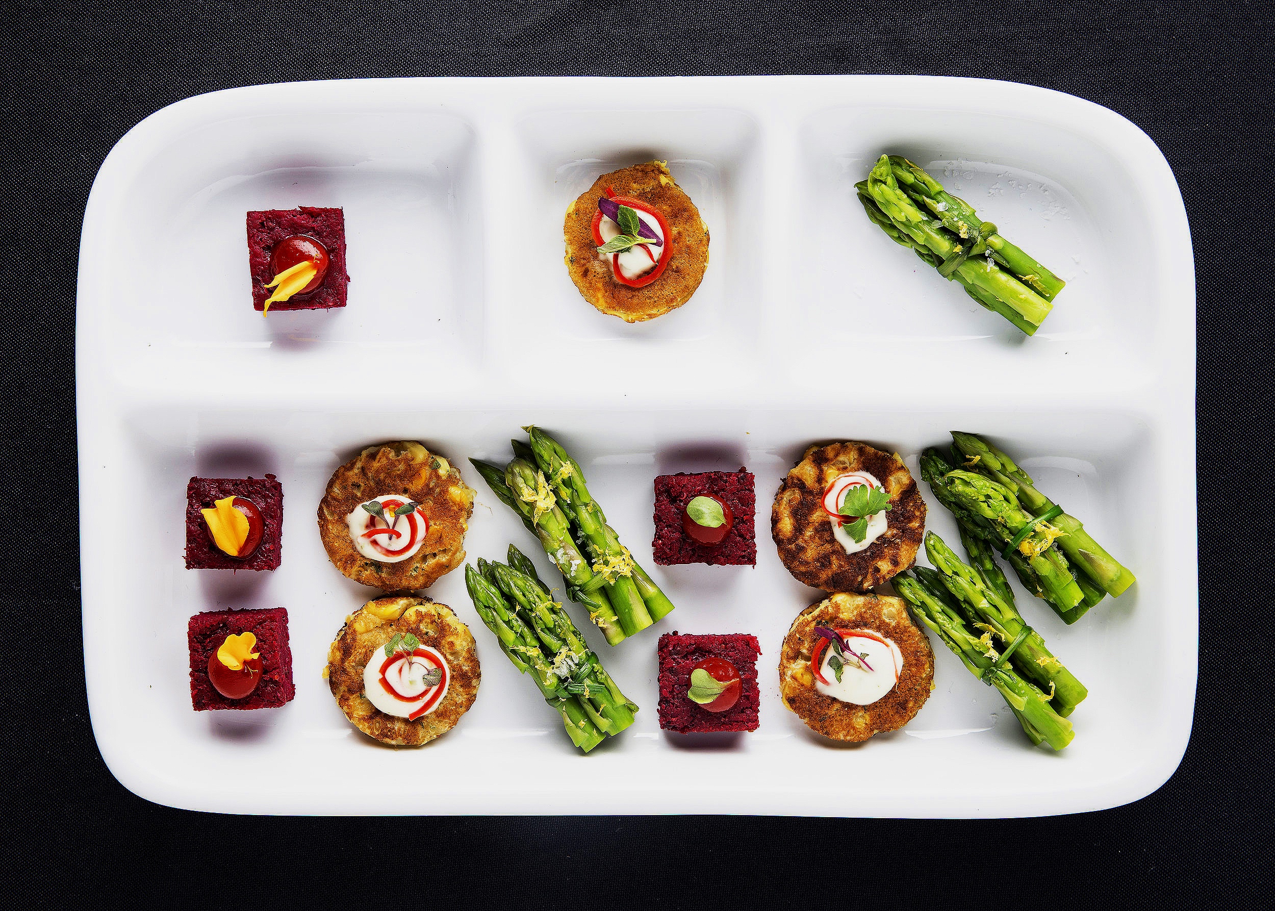 Vegan tv dinner with beetloaf, corn fritter with vegan aioli and anaheim chile, and asparagus