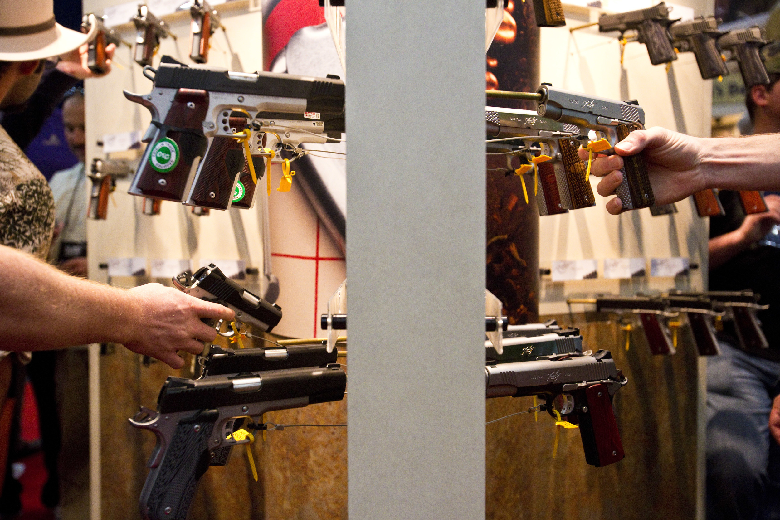  Attendees look at semi-automatic handguns at the 2013 National Rifle Association Meeting and Exhibits May 4, 2013 in Houston. 