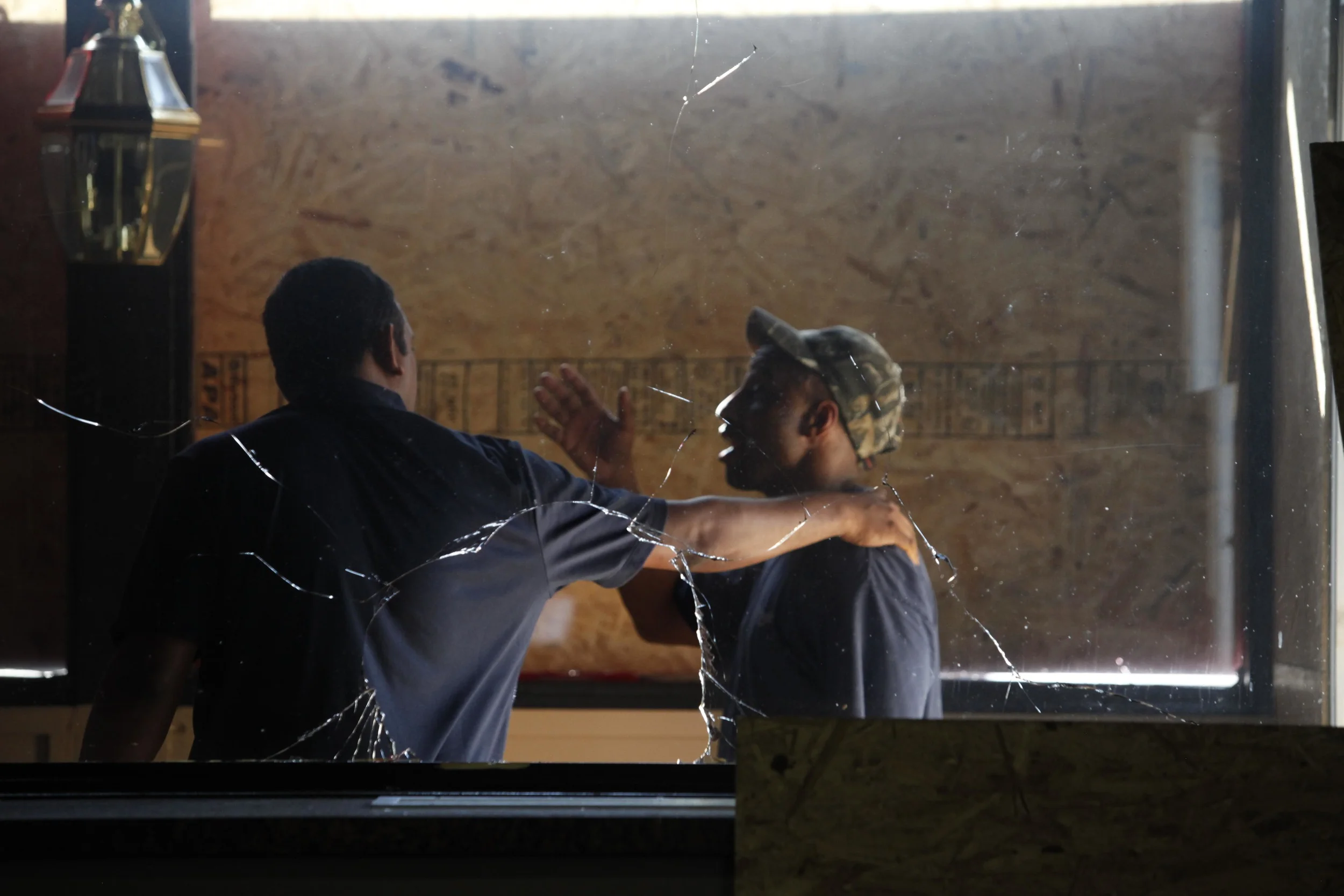 The owner of Red's Barbecue, left, speaks with a man making repairs to the restaurant.