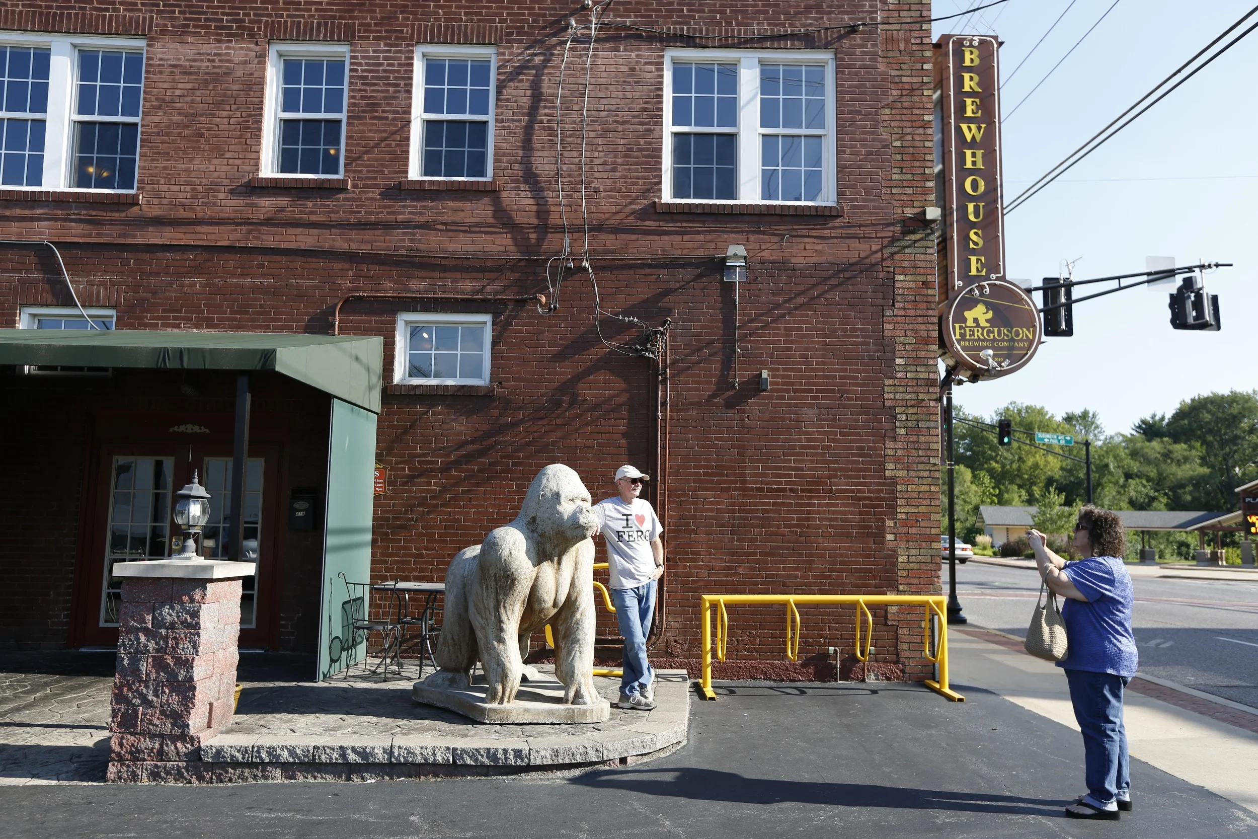 Linda Owen takes a photo of her husband Al August 19, 2014 in Ferguson, MO in front of the Ferguson Brewing Company. The couple are from an unincorporated section of St. Louis County and were visiting Ferguson to help support the town.