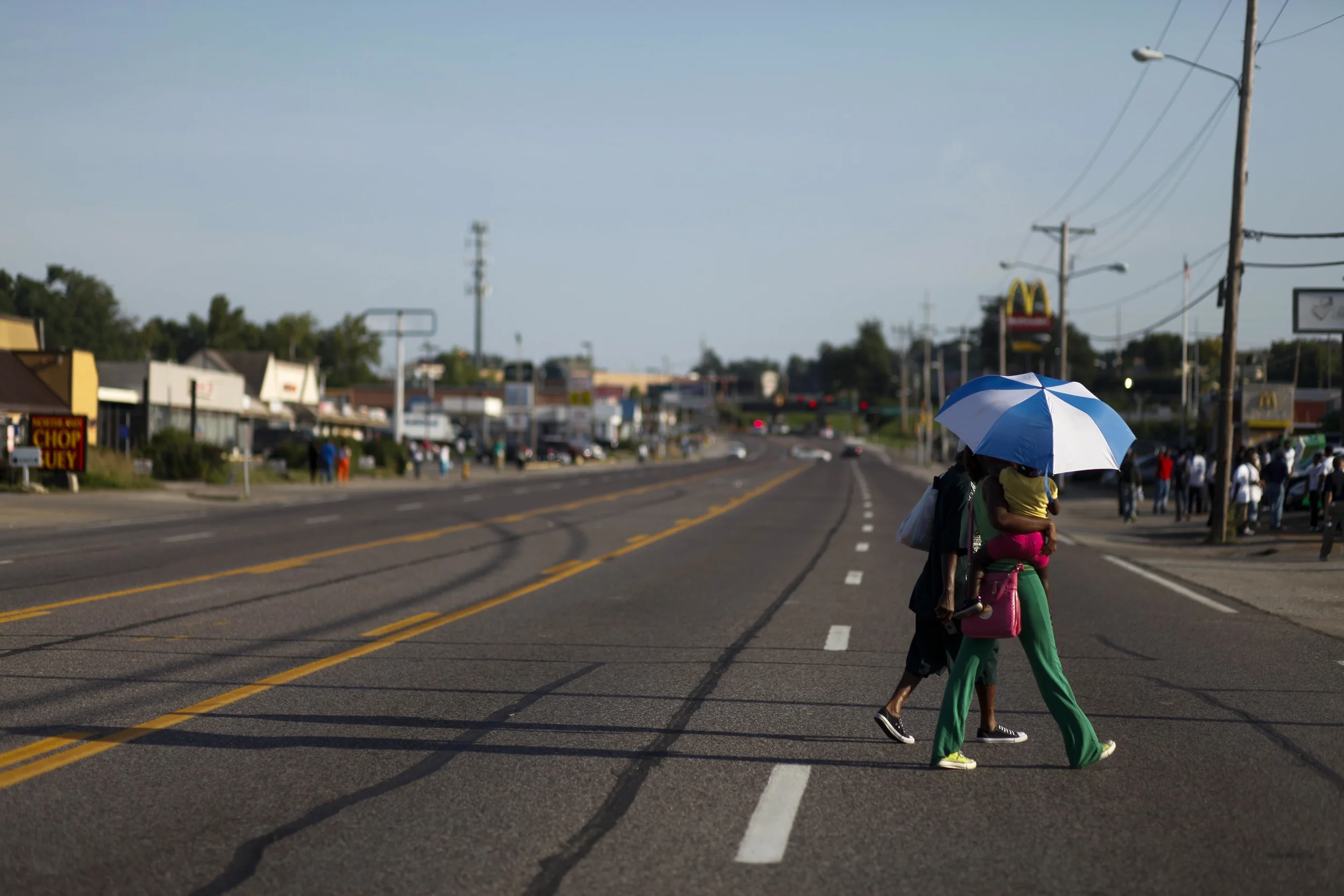 People cross W. Florissant Ave. as evening approaches August 20, 2014 in Ferguson, MO. The protest that evening was smaller and more calm than prior evenings.
