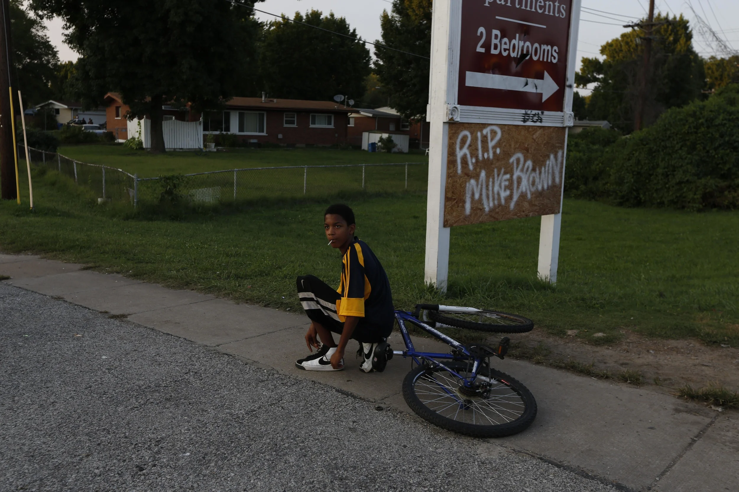 A child stops to tie his shoe along W. Florissant Ave. August 19, 2014 in Ferguson, MO. W. Florissant Ave. has been the location of protests and occasional rioting related to the shooting of an unarmed Michael Brown by Ferguson police.