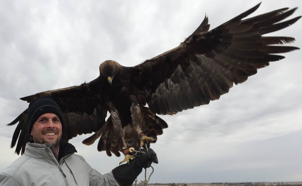  Revere La Noue with a rehabilitated Golden Eagle named Miles shooting on restored prairie land in Oklahoma while filming for OVERLAND. 