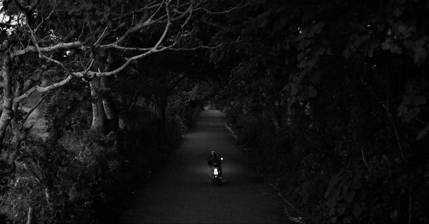 A motorcycle rides down the Carretera a Suchitoto de Ciudadela