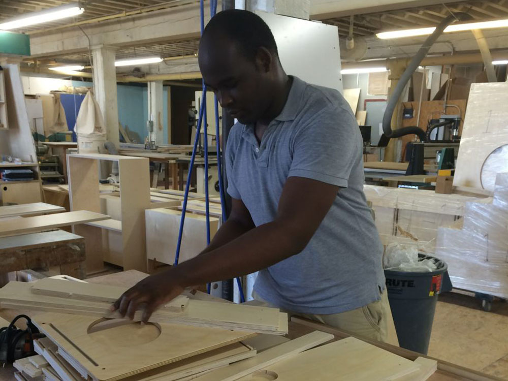 Tulio Santos organizing the CNC-cut wood parts for sanding and assembly