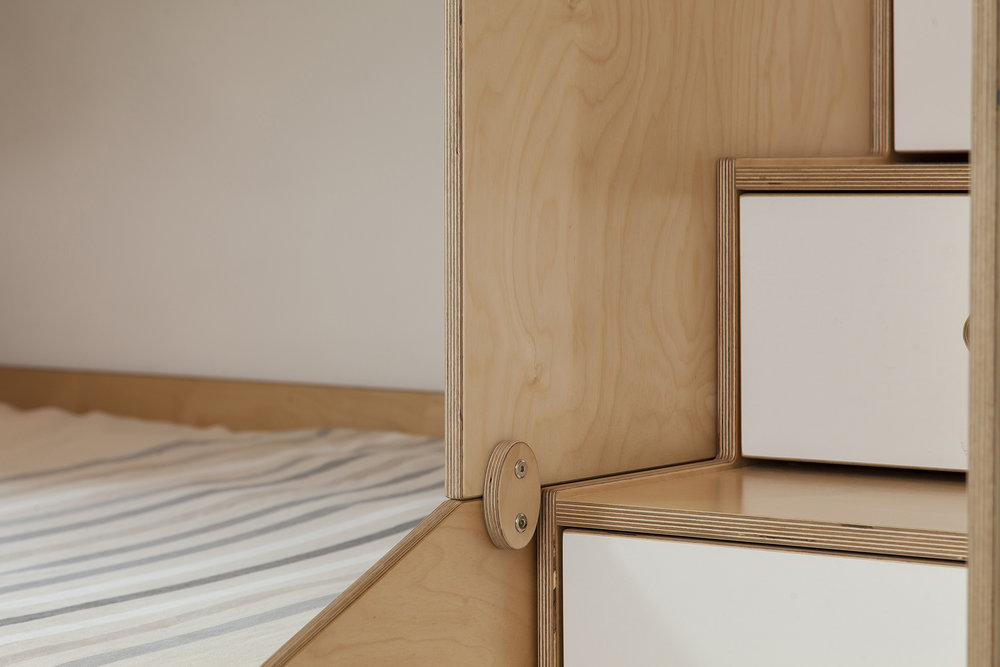 Minimalist wooden bed frame with white mattress in a simple design.