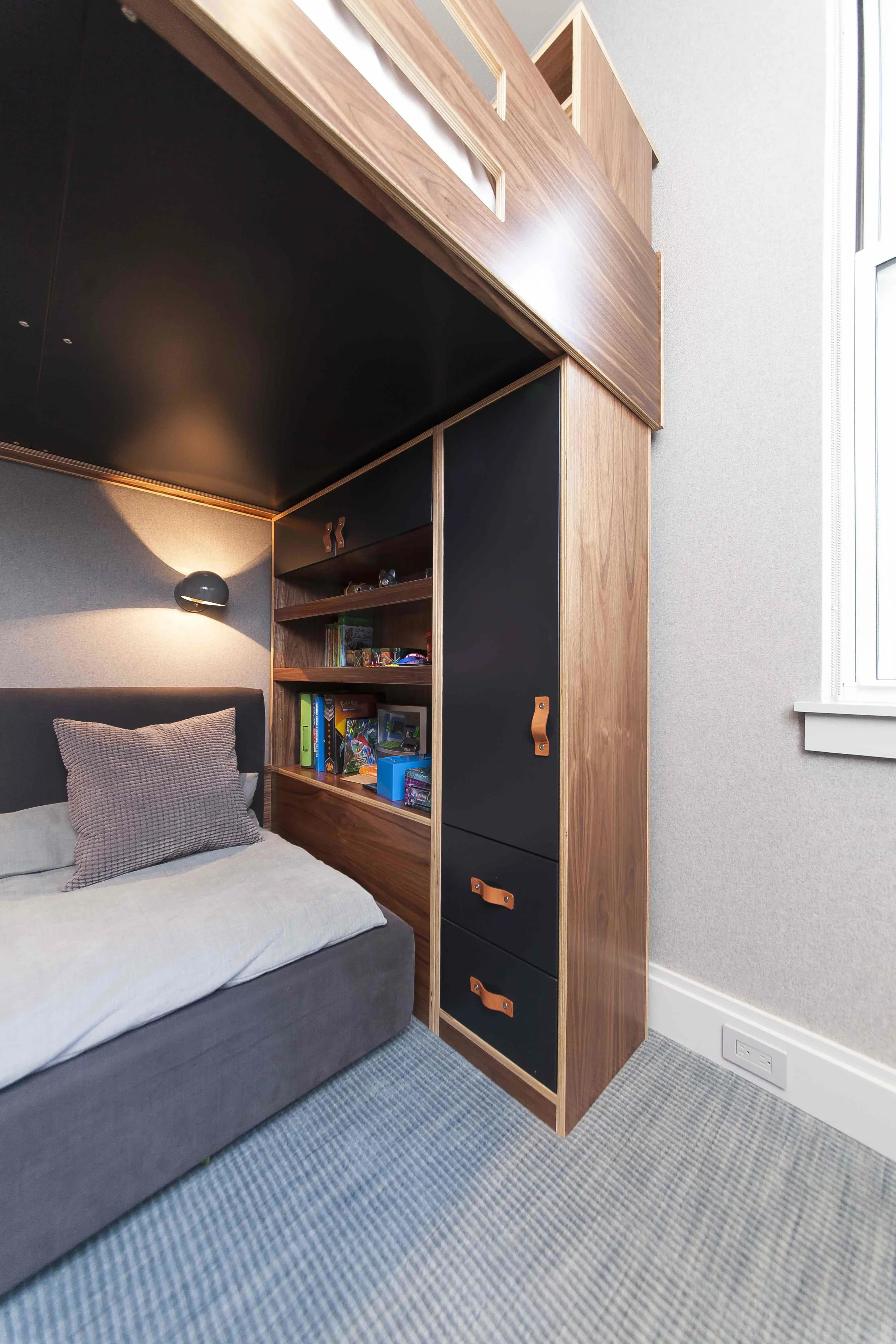 Custom cabinet holding up a loft bed.