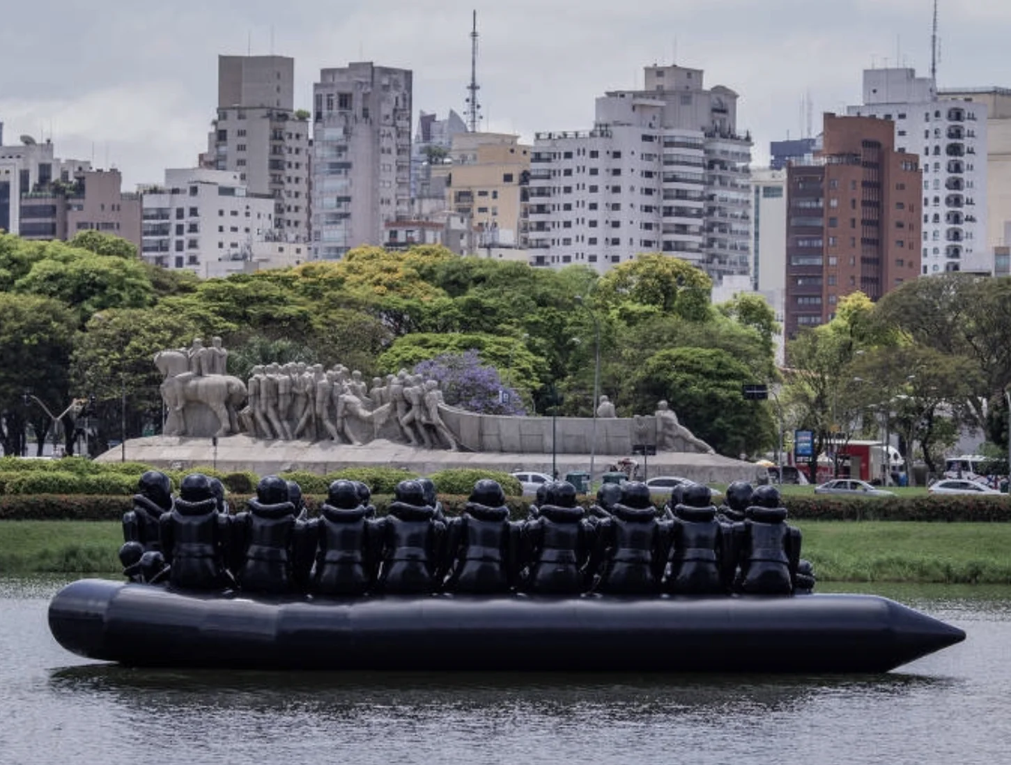 The Law of the Journey, um gigantesco bote inflável com imigrantes igualmente infláveis que flutuou por 24 horas no lago do Parque Ibirapuera antes da abertura da maior exibição individual do artista.