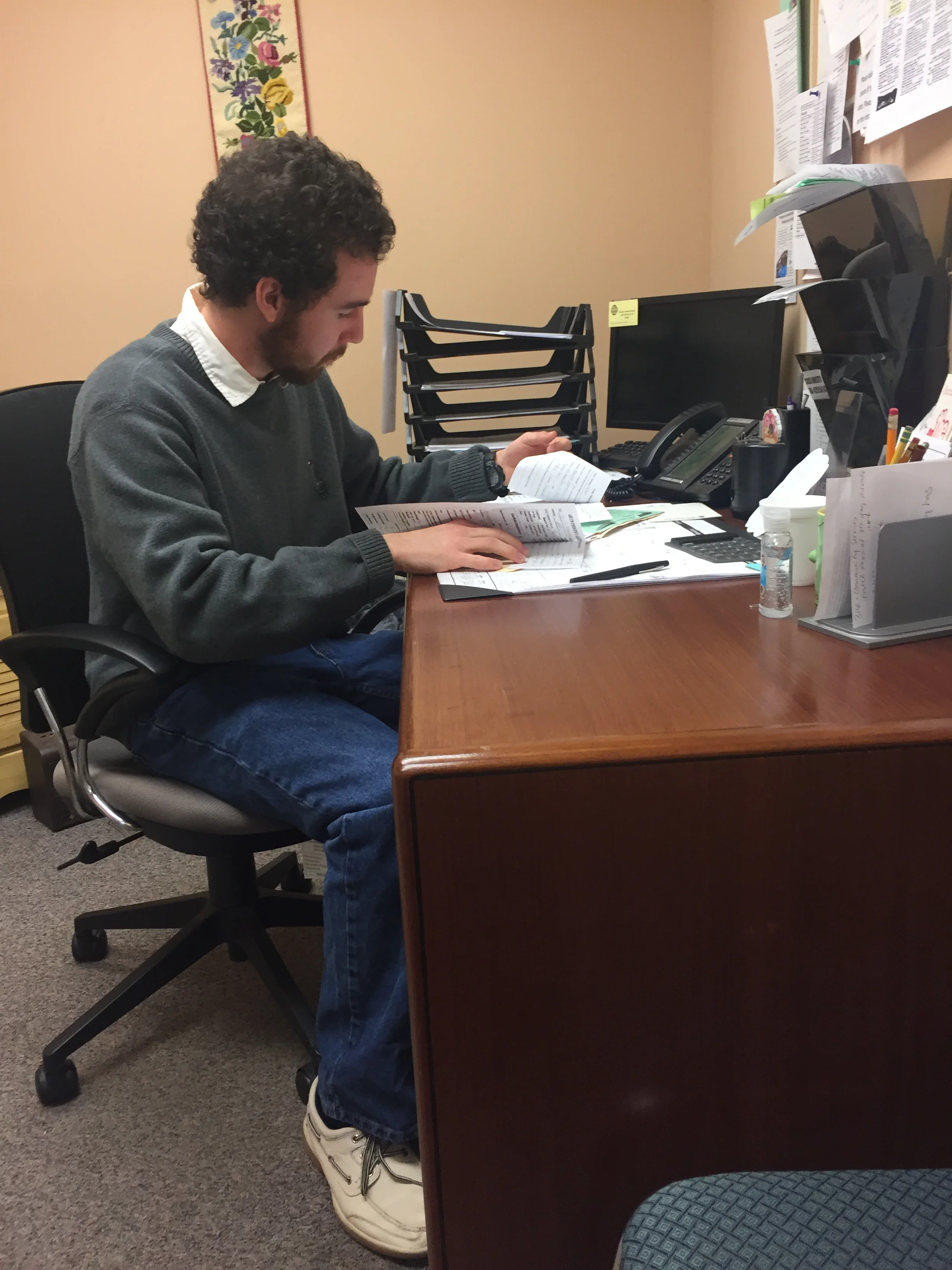 UNC Asheville senior David Johnson, who volunteers as a counselor in the Crisis Ministry, goes through a client's paperwork before a meeting. Johnson sees how grateful clients are when they're able to get assistance with food.