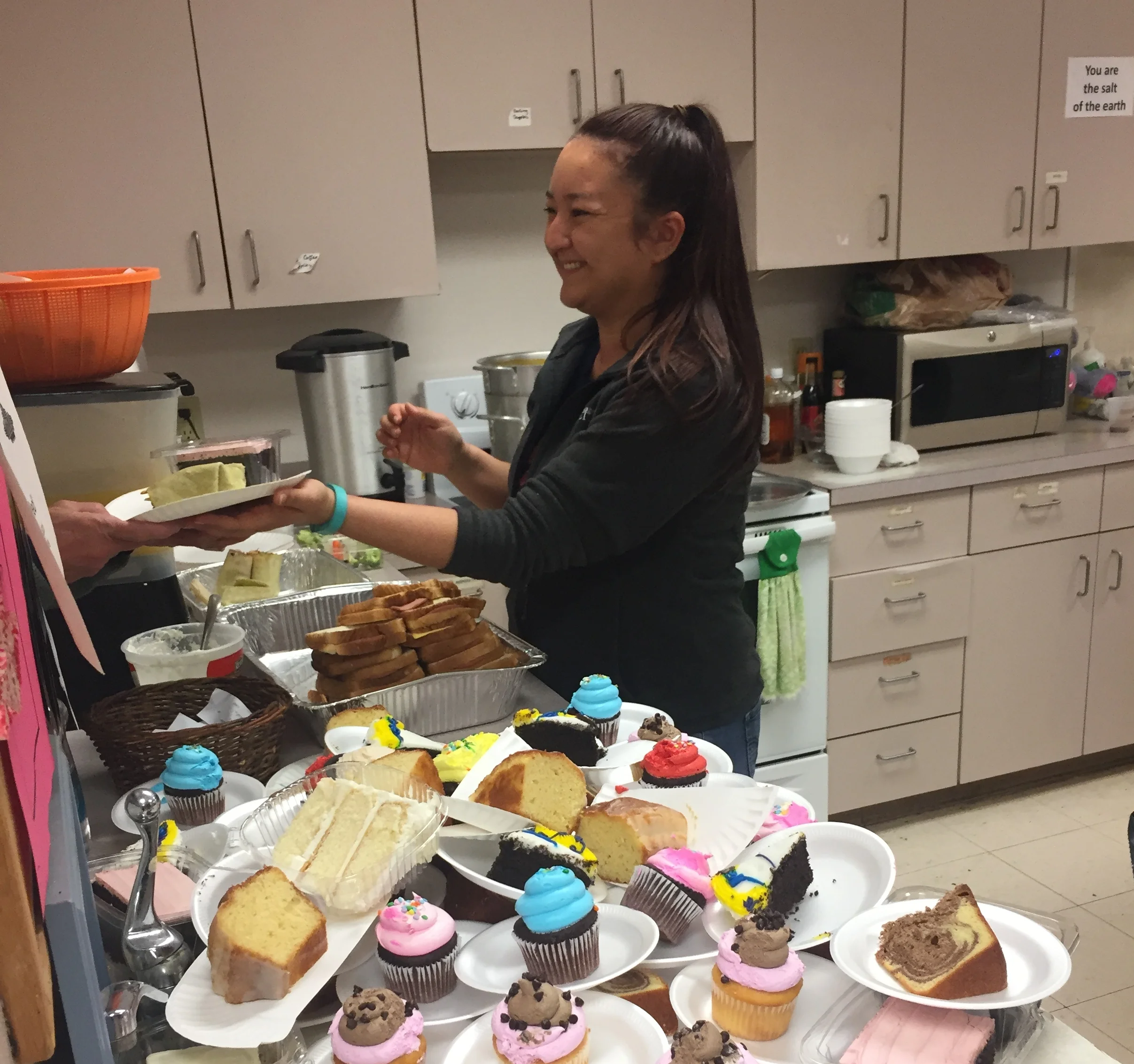 Crisis Ministry volunteer Jenny Brooks serves dessert to a client during a recent soup kitchen lunch.