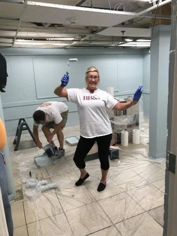 A BB&T Lighthouse volunteer takes a break while painting the educational playroom at Steadfast House. The blue paint color was chosen specifically according to principles of trauma-informed care.