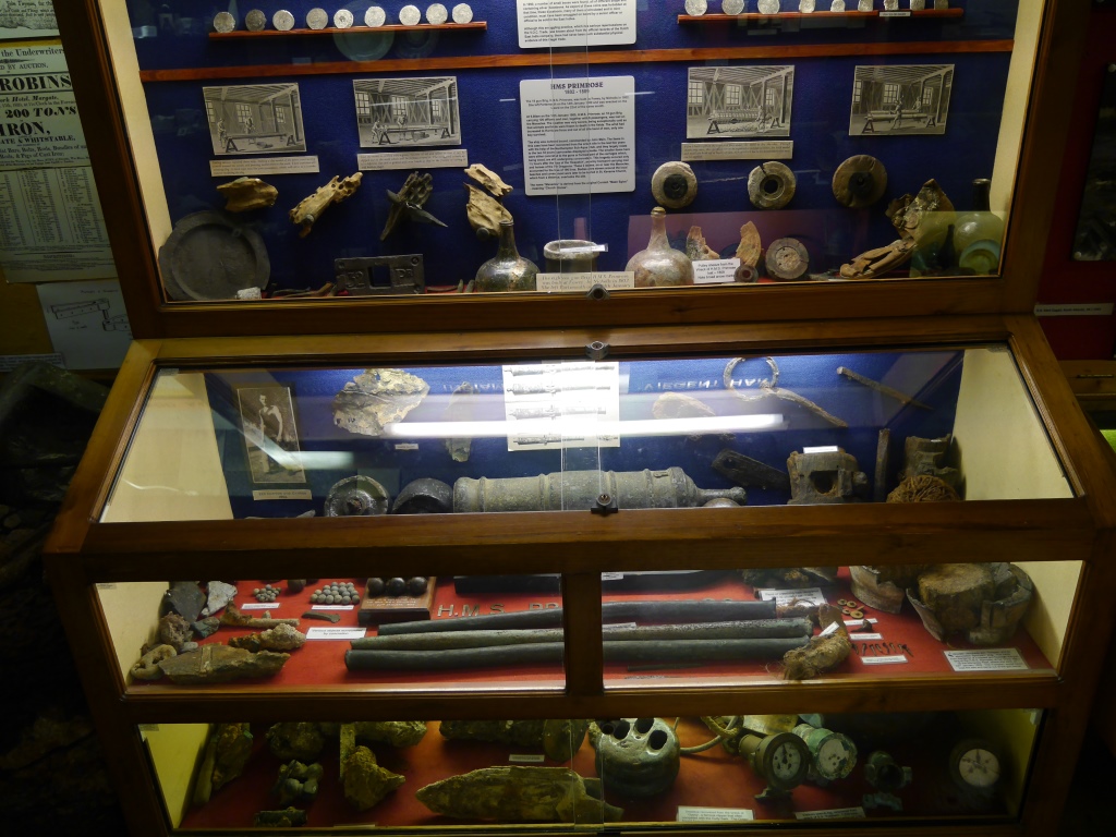 Artefacts from Primrose are displayed in the lower part of the upper case and the top shelf of the lower cabinet ( Charlestown Shipwreck and Heritage Centre ). Click to enlarge; see below for close-up views.