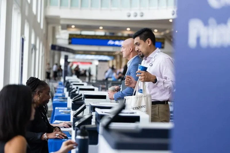 People standing in line at airport check-in counters, interacting with airline staff.