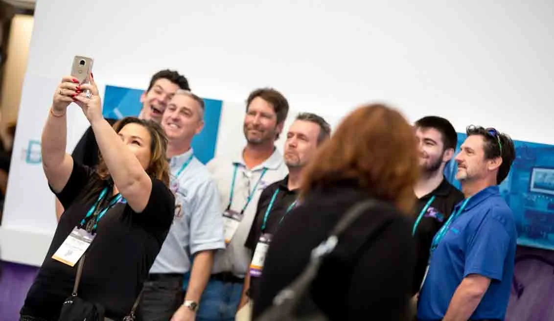 Group of people at a conference taking a selfie.