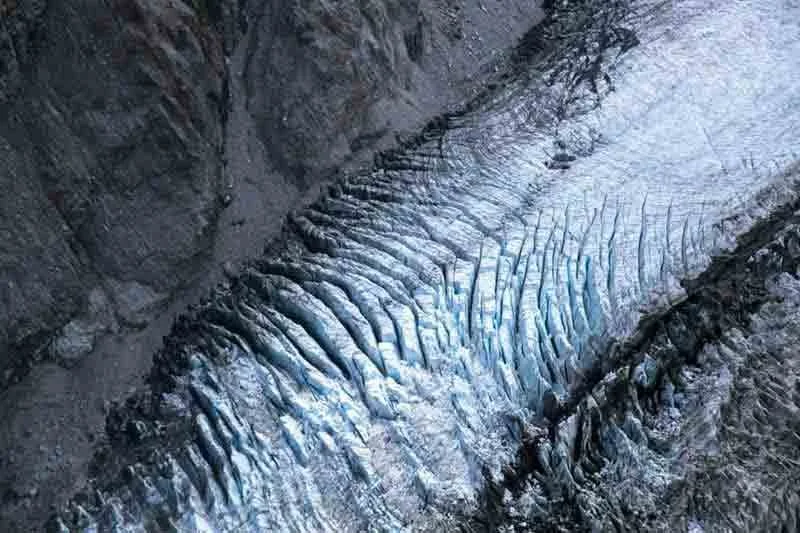 Aerial view of a glacier with crevasses.