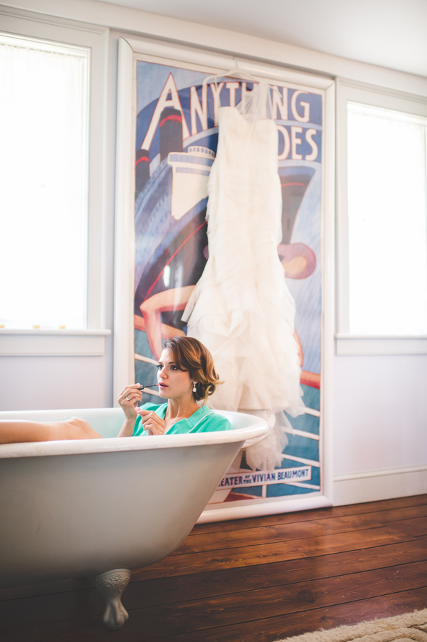 great shot of bride applying makeup in a clawfoot tub | photo by Jessica Oh Photography