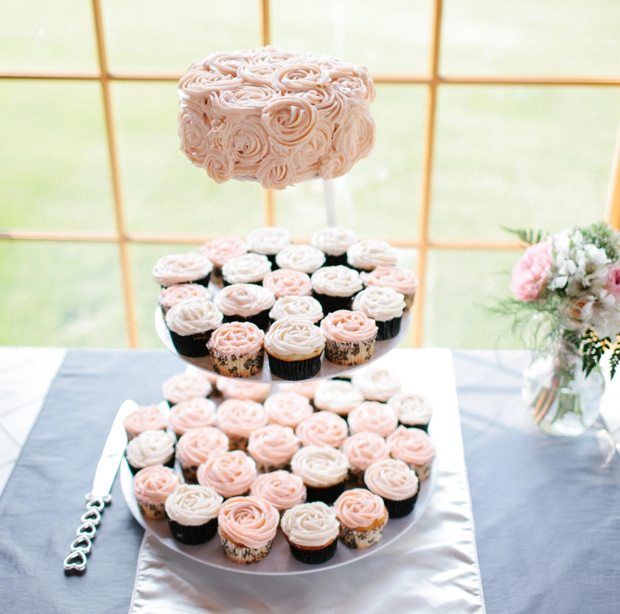 Light Pink Wedding Cupcakes topped with a Rosette Frosted Cake | photo by blf Studios | wedding by Madeline's Weddings
