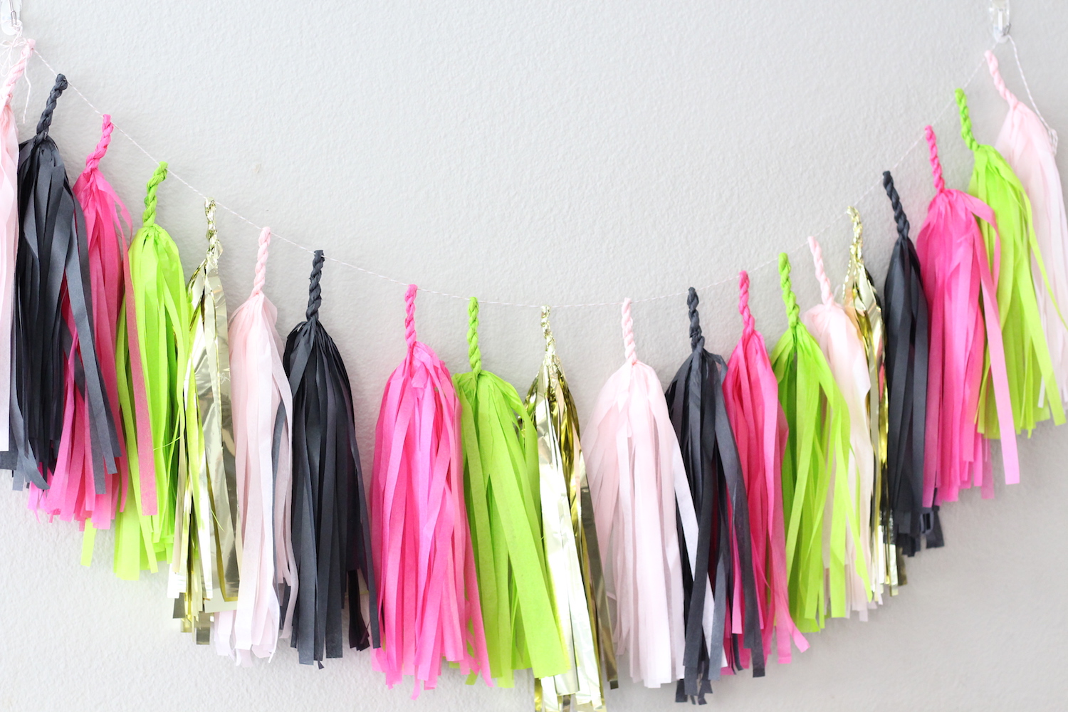Color Coordinated Tassel Garland for a Let's Flamingo Bachelorette Party {or a bridal shower, even a bridal brunch as the theme is super versatile}. Hot Pink, Black, Gold and Green Color Palette. As seen on www.brendasweddingblog.com