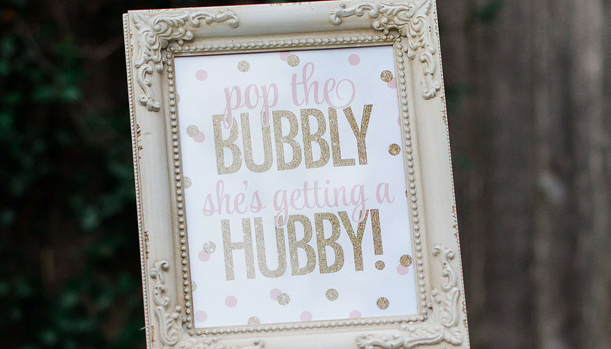 A framed "pop the bubbly she's getting a hubby" printable is perfect as added party decor — Click to see 8 DIY Wedding Ideas for a Springtime Bridal Shower Brunch — Part of the 37 Creative DIY Wedding Ideas for Spring as seen on www.BrendasWeddingBlog.com