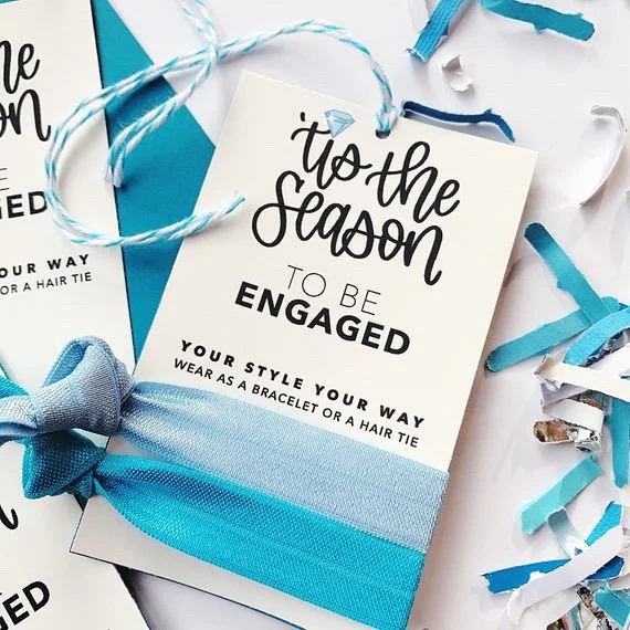 &rsquo;Tis the Season to be Engaged - these hair tie cards from my @festivefetti #EtsyShop can be used as a gift tag for the Bride to Be&rsquo;s present, tucked into the wedding planner or photographers welcome kit, or even as bridal shower favors. Available as a card or gift tag with twine. Click my profile link to shop for yours today.⠀
-⠀
-⠀
-⠀
-⠀
-⠀
#somethingblue #engagementseason #etsywedding #etsyweddings #instaweddings #smallbusinesslove #partystyle #shophandmade #etsyshopowner #festivefetti #brendasweddingblog #designisinthedetails #sobestfriendsforfrosting #ohwowyes #itshappyhere #eventstylists #makewavesmonday #hairties #hairaccessory #bridestyle #bridestyling #welcomekit #colorgram #bridesmaidsgifts #engagedtothedetails #huffpostlifestyle #gifttags