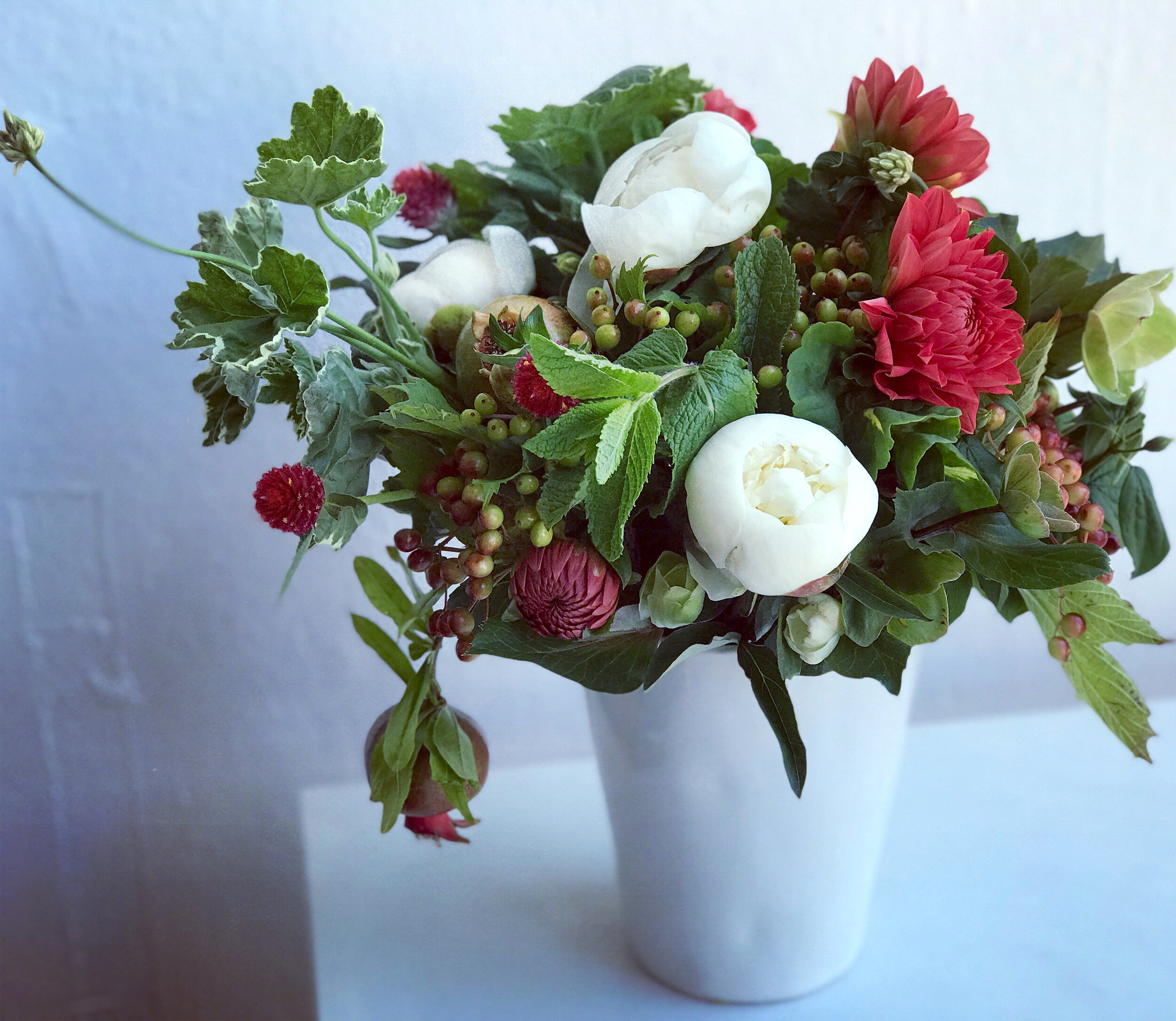 The prettiest of wedding centerpieces with mint, geraniums, peonies, dahlias, and the unexpected addition of fruit - pomegranates,. Come see all the details on adding fruit to your wedding day from Bloomin Couture on Brenda’s Wedding Blog www.brenda…