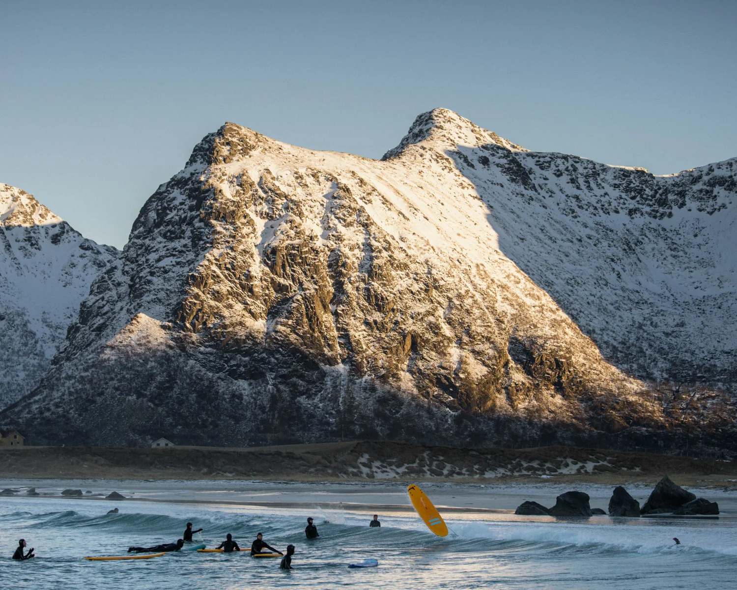 A group of visitor is learning to surf on the spot of Flakstad in the lofoten islands
